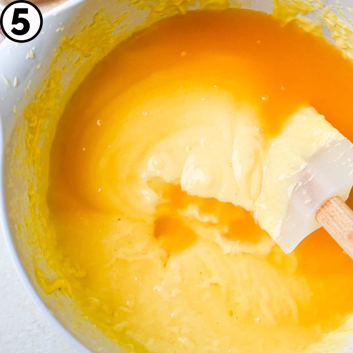 Stirring rum and syrup into the cake batter. 