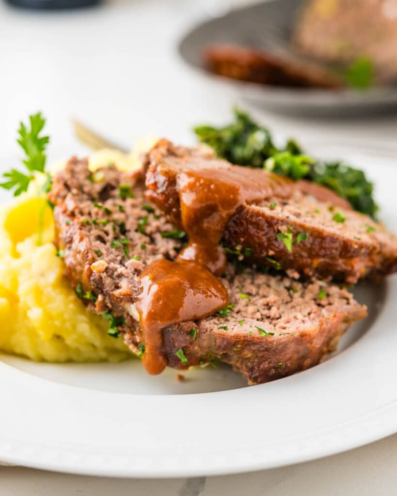 Old fashioned glazed meatloaf on a plate with side dishes.