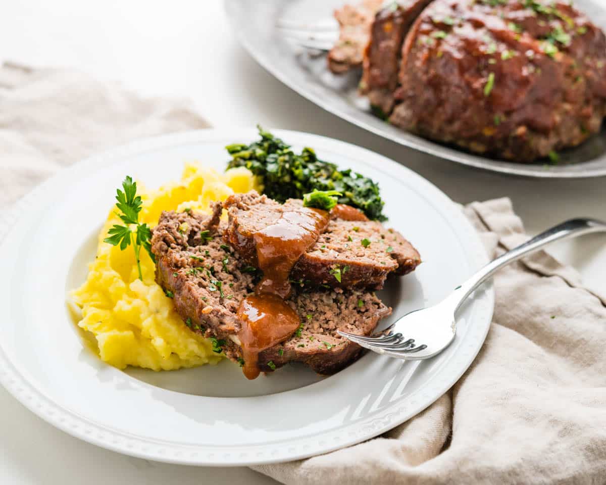 Serving the classic meatloaf with mashed potatoes and spinach.