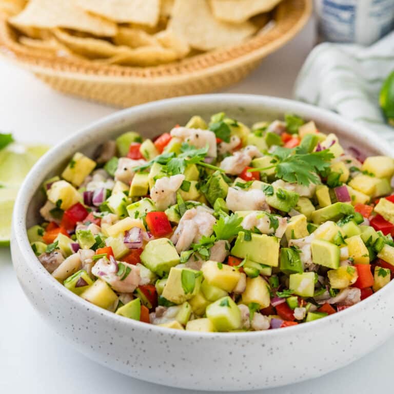 Fresh ceviche in a white bowl with tortilla chips.