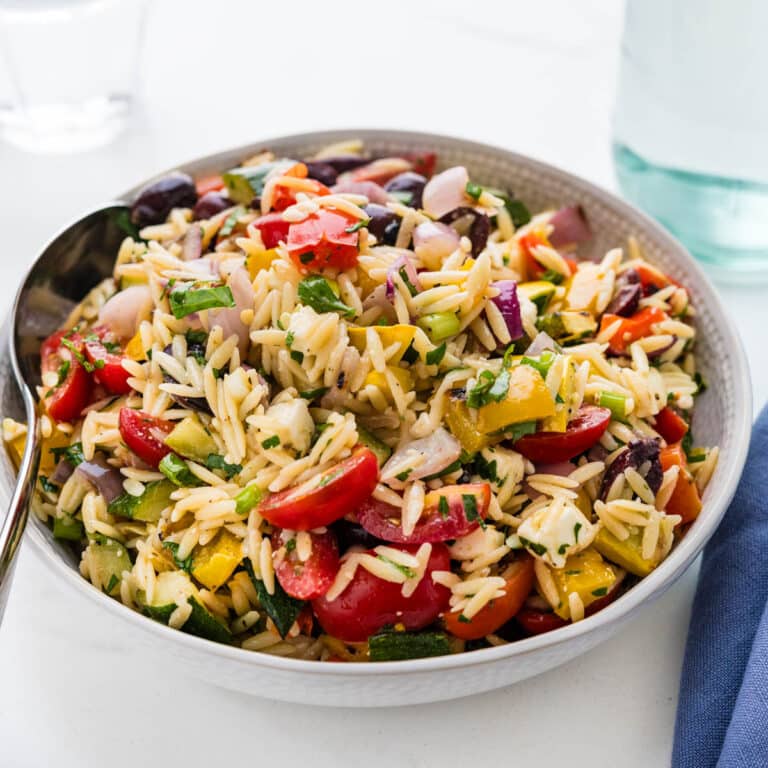 A bowl of grilled vegetable salad with orzo pasta.