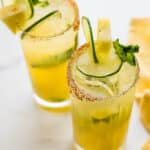 Pineapple mojitos with lime wedges.