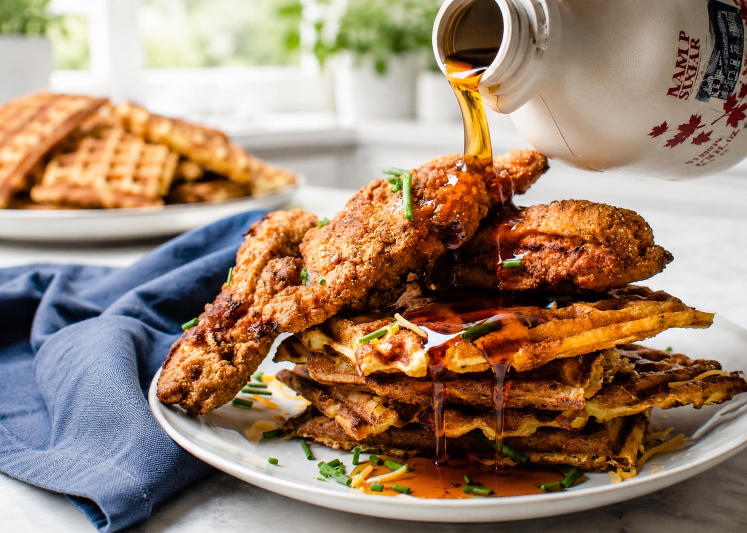 Pouring syrup of the fried chicken and waffles.