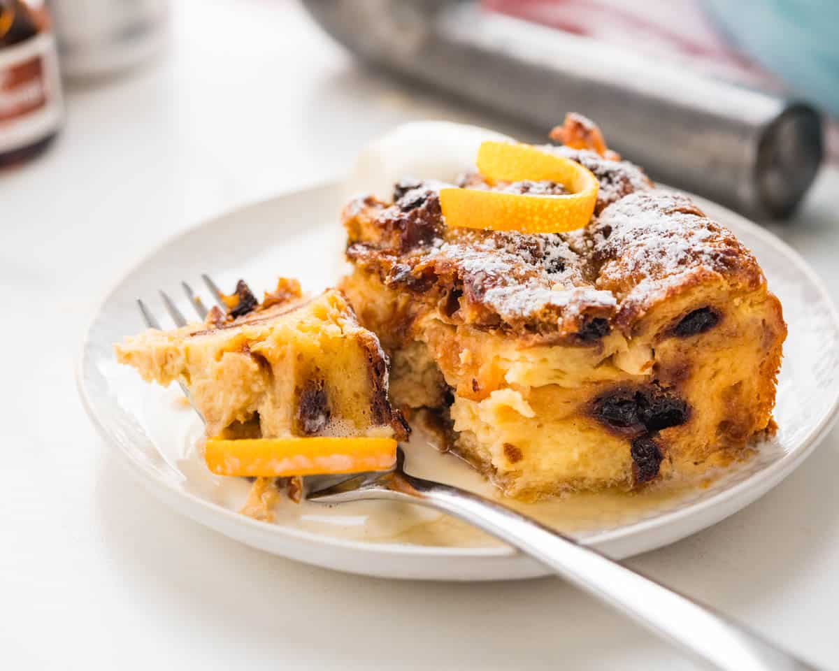 A dish of bread pudding from Pannetone with an orange peel decoration.