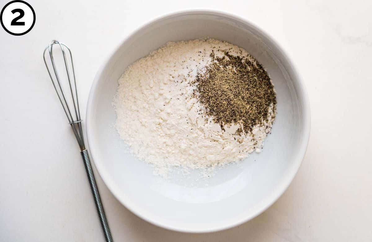 Mixing flour, salt and pepper in a bowl.