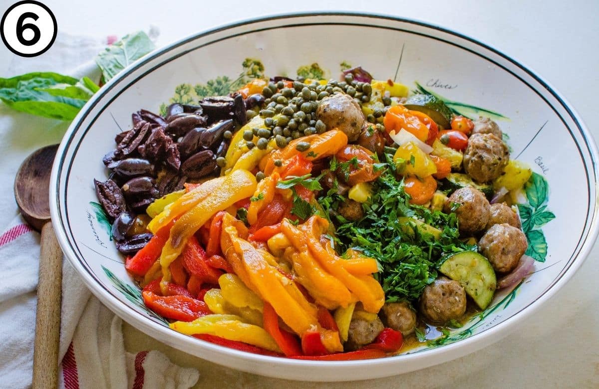 Combine the roasted vegetables, sliced peppers, olives, capers and sausage.