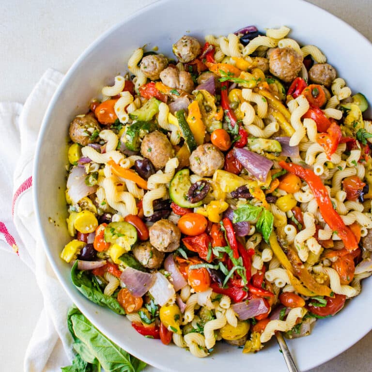 A bowl of the sausage and peppers pasta with fresh basil.