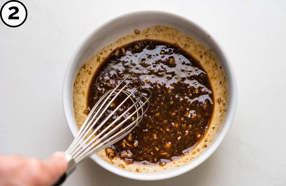 Whisking balsamic into the bowl.