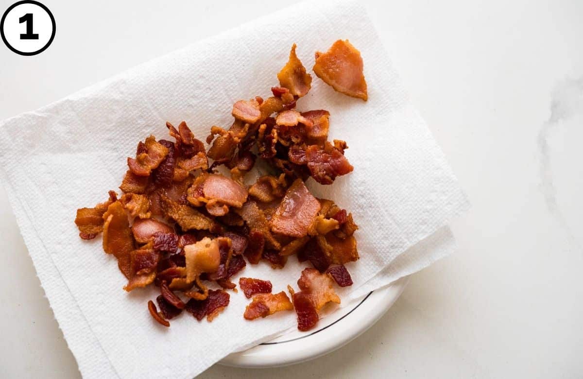Draining the bacon after sautéing in the pot.