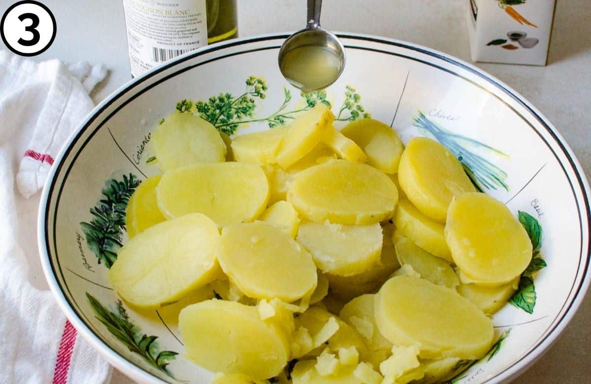 Adding wine and stock to the potatoes.