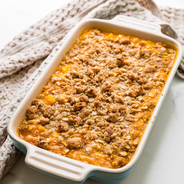 Hot and oozy baked mango crisp in a small casserole dish.