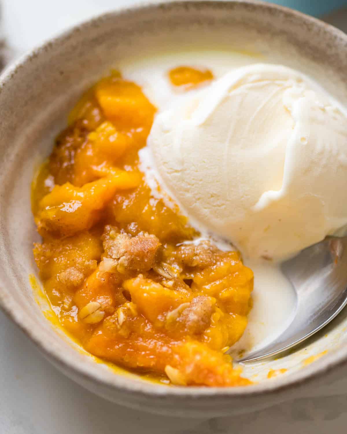 The ice cream melting into the hot fruit crisp.