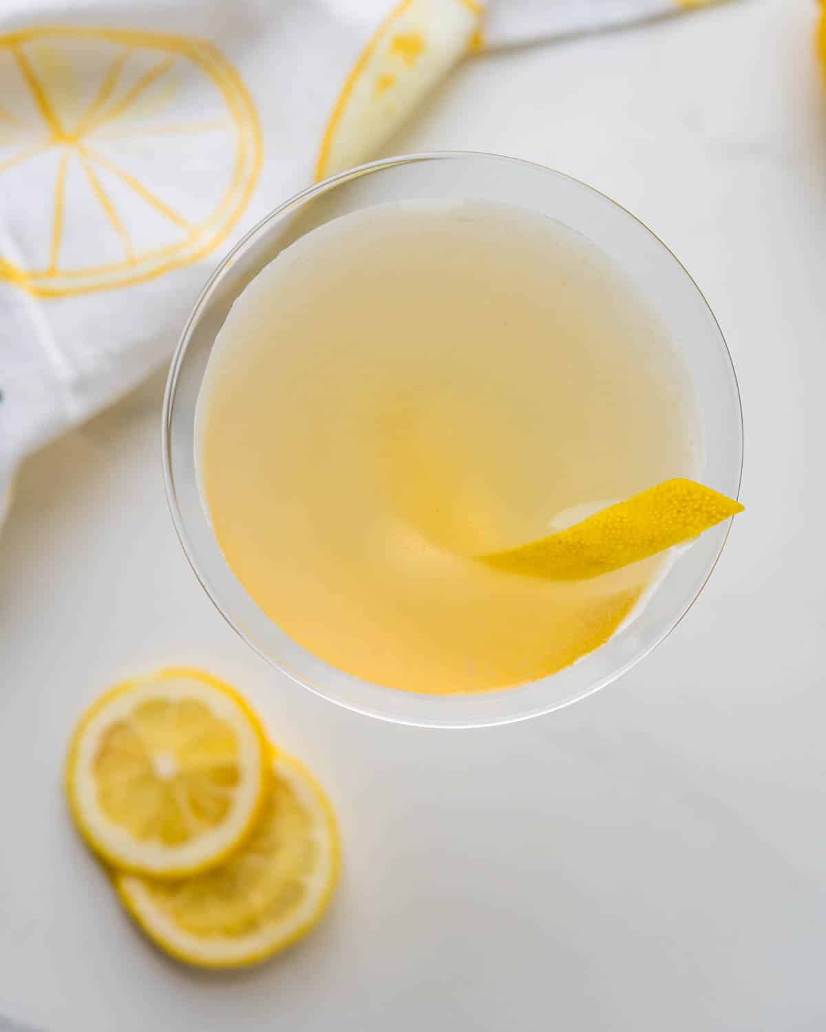 An overhead shot of a Lemon-garnished gin cocktail in a martini glass.