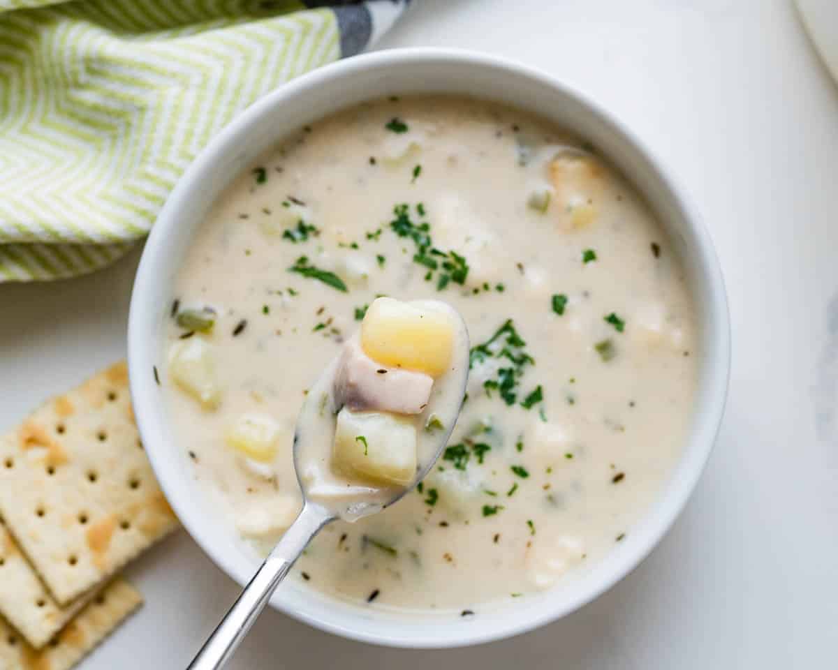 Spooning up the chowder from the bowl.