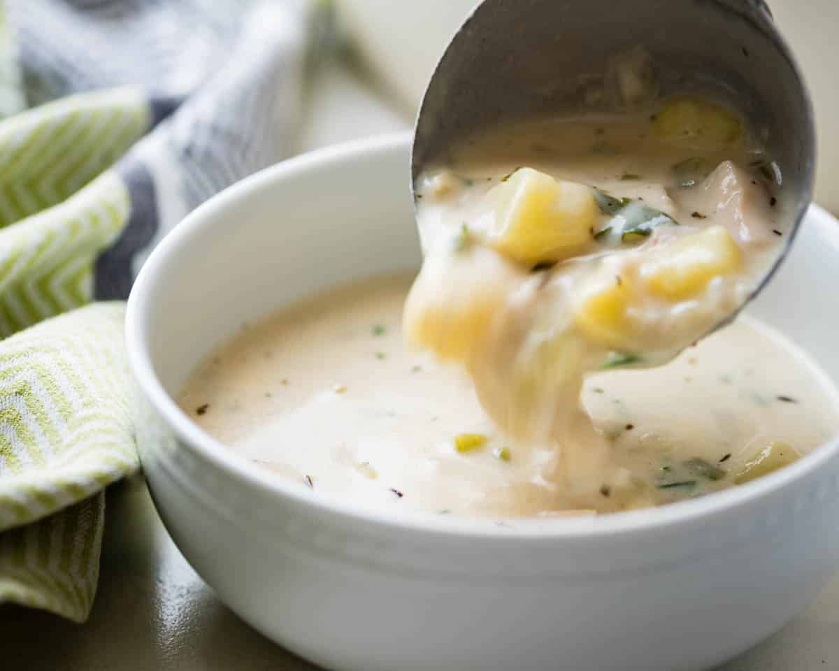 Ladling chowder into a bowl.