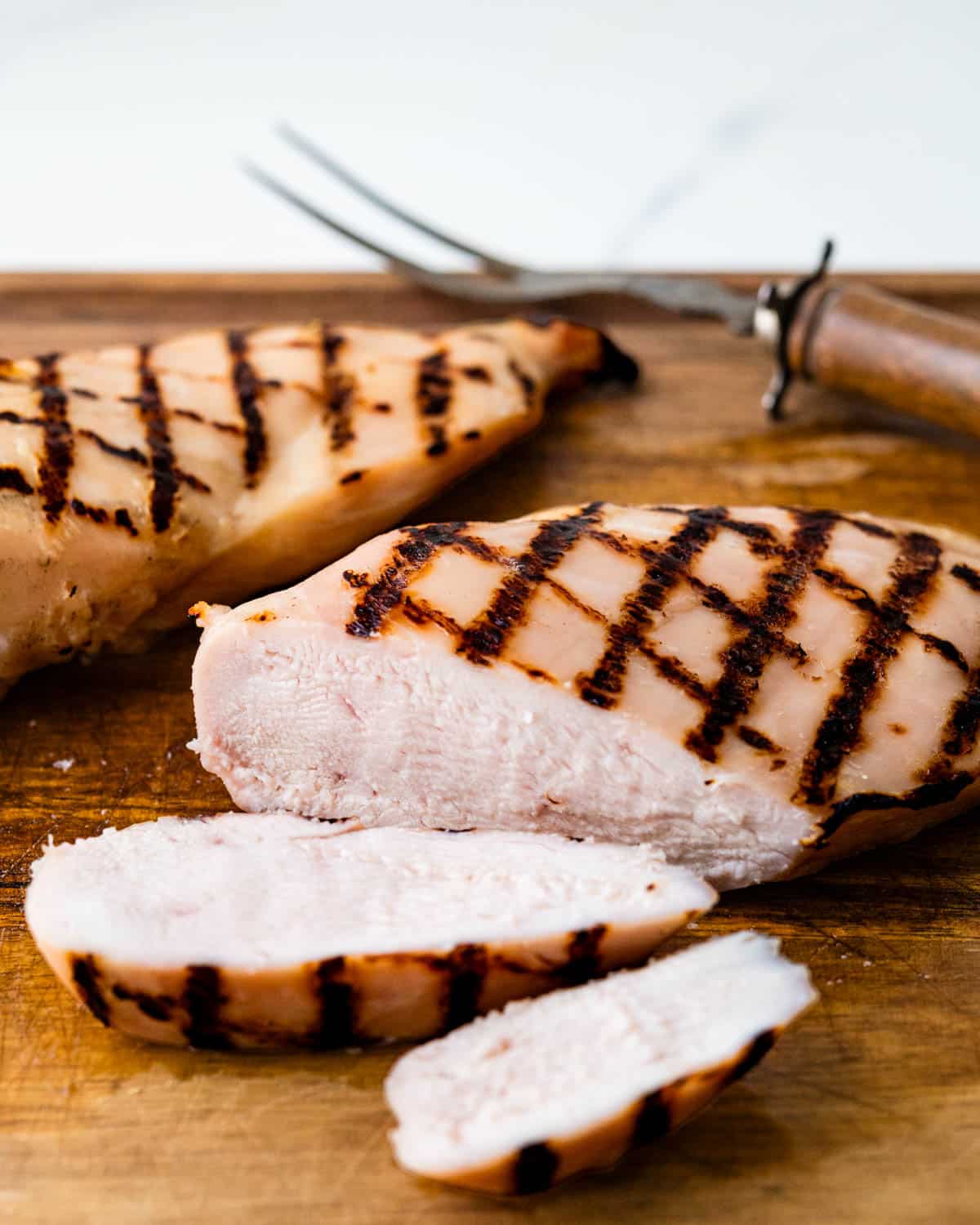 Brined grilled chicken being sliced.