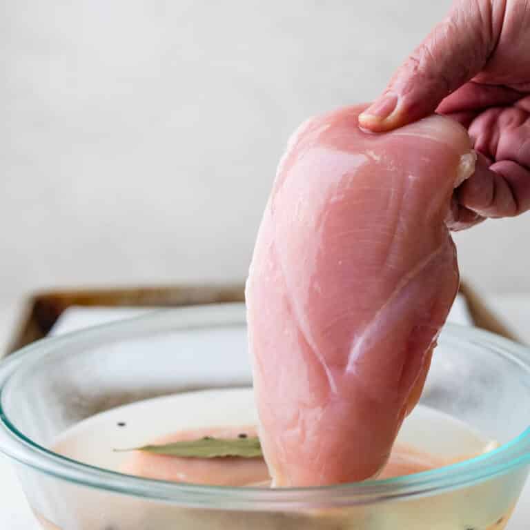Pulling a chicken breast from the brine.