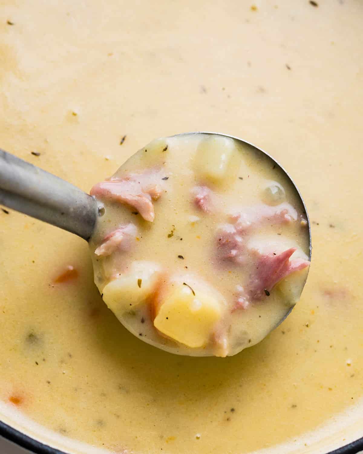A ladle of the potato soup with ham.