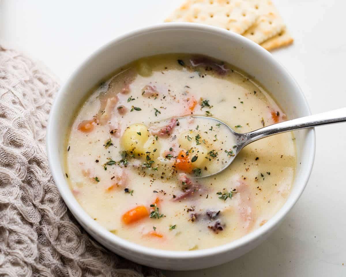 Spooning up a bit of ham and potato soup from the bowl.