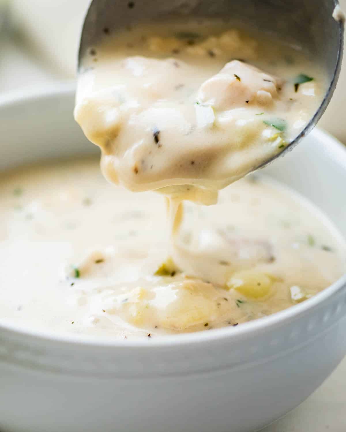ladling fish chowder into a bowl.