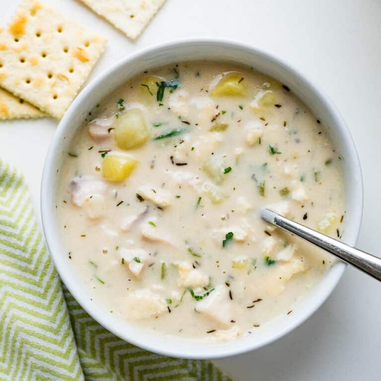 Homemade fish chowder in a bowl with a few saltines on the side.